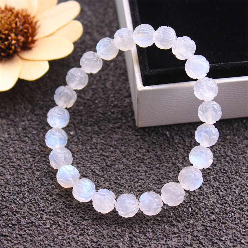 Natural Moonstone Lotus Love Bracelet - close-up on textured gray surface, spiritual jewelry