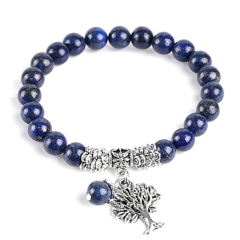 Tree of Life lapis lazuli bracelet with deep blue beads and golden pyrite flecks, silver tree-of-life charm, silver floral spacers, lapis dangle.