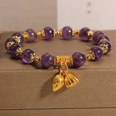 Natural Amethyst Lotus Healing Bracelet - purple beads with gold lotus charms on neutral display, spiritual