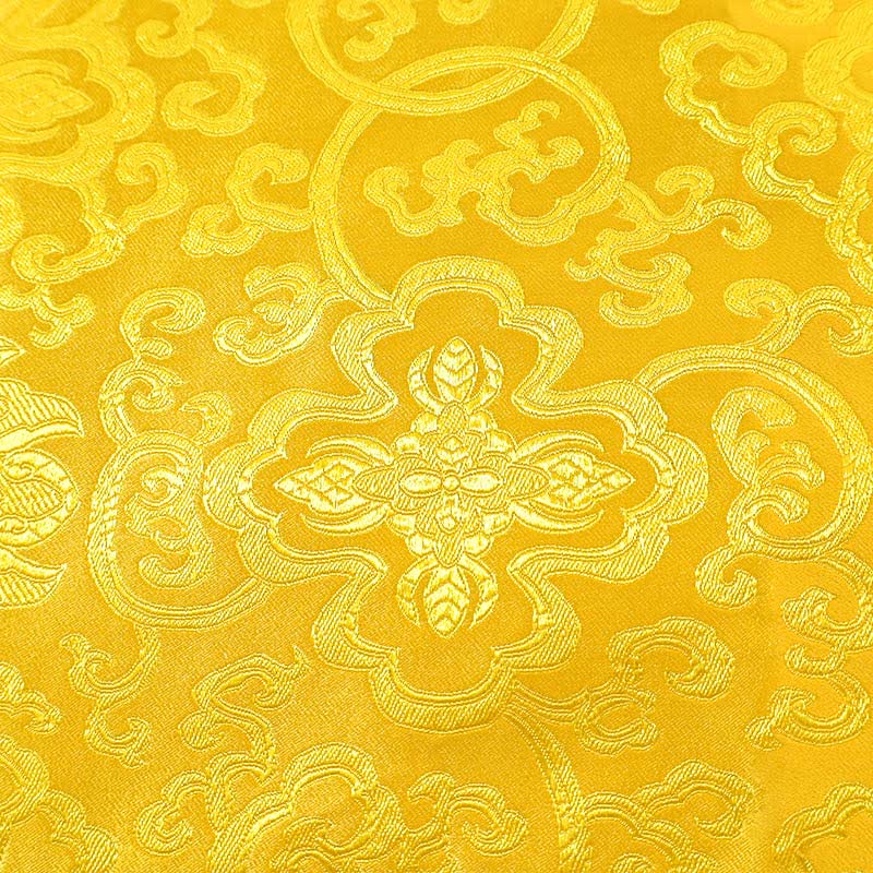 Tibetan Dragon Prayer Mat - Close-up golden brocade fabric with floral medallion and cloud scroll weave, Protection