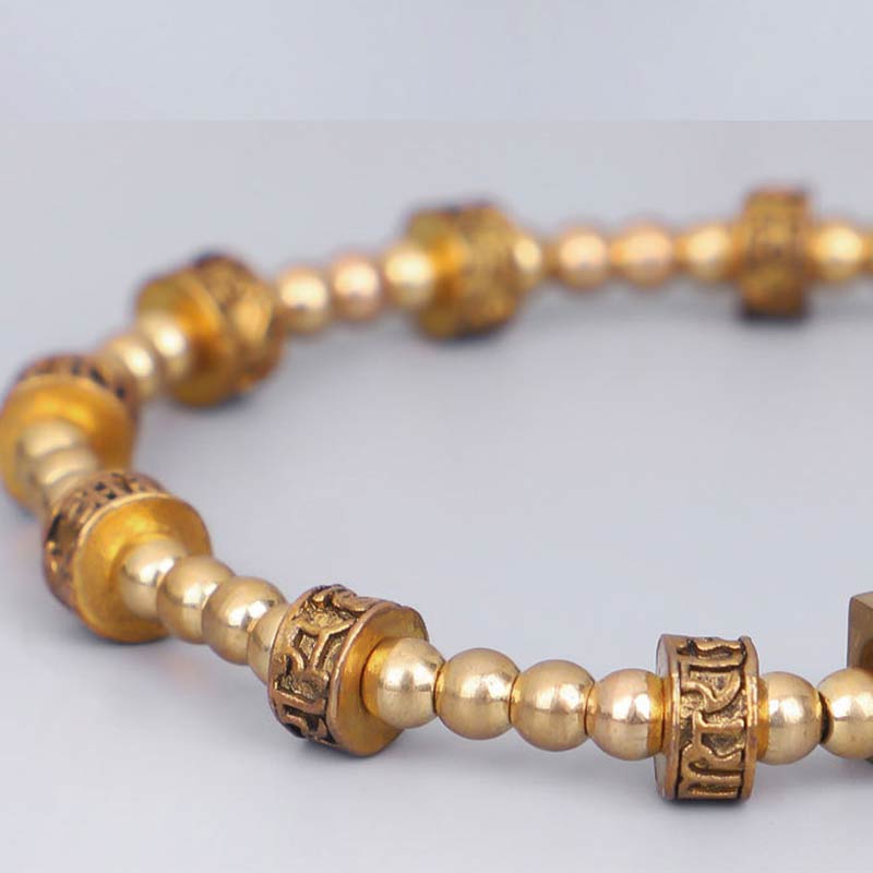 Tibetan Gold Om Mani Padme Hum Bracelet – Diagonal view revealing engraved barrel bead details, gold mala