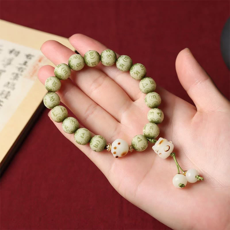 Bodhi Seed Bracelet – Green carved beads with cat charm displayed on open palm, mindfulness jewelry