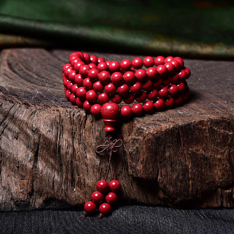 108 Mala Beads Cinnabar Bracelet – Coiled stack on wooden slab, tassel pendant