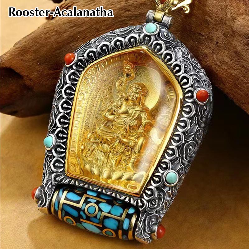 Tibetan Zodiac Buddha Dzi Bead Necklace – Gold deity figure in silver cloud-pattern frame with turquoise coral stones on chain, brown wood with tan fabric lifestyle frontal