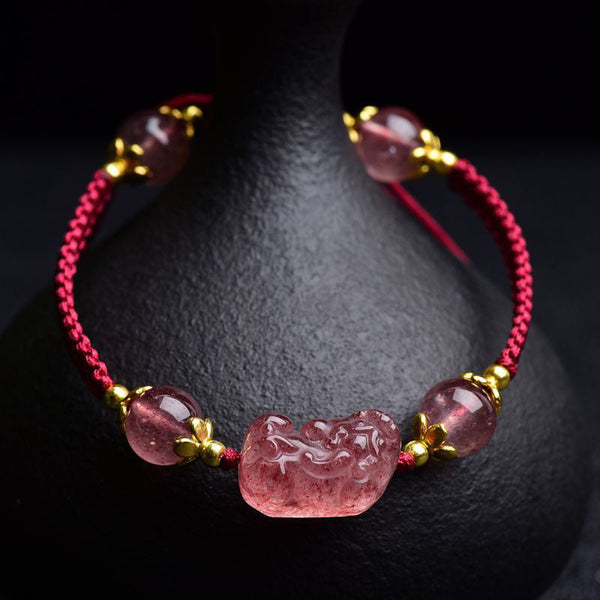 Strawberry Crystal PiXiu Charm Lucky Red String Bracelet – front view with pink crystal beads and gold spacers on black stand, feng shui good luck jewelry