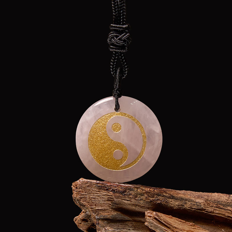 Yin Yang Crystal Necklace – Rose quartz crystal pendant with gold yin-yang symbol, natural pink translucent stone on black co