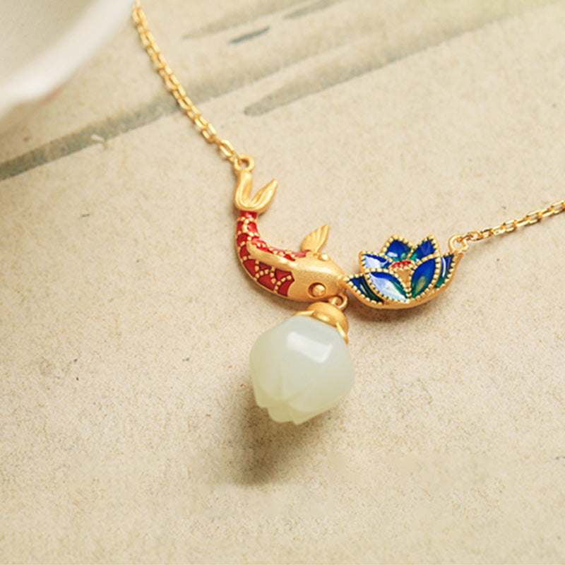White Jade Koi Fish Necklace – close-up on cream paper, red blue enamel koi lotus pendant with jade teardrop dangle