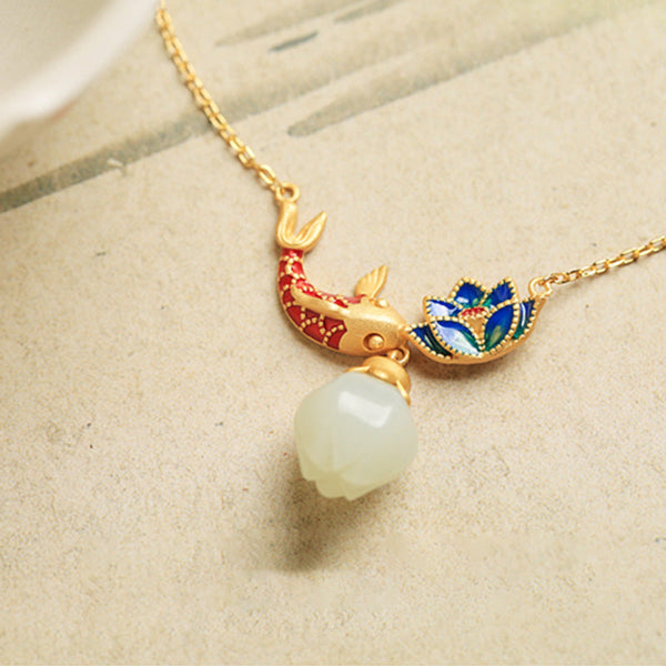 White Jade Koi Fish Necklace – close-up on cream paper, red blue enamel koi lotus pendant with jade teardrop dangle