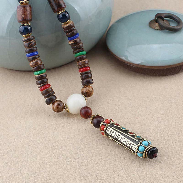 Wenge Wood Dzi Bead Mantra Necklace - Angled view of wood bead necklace with cylindrical bronze mantra pendant