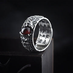 PiXiu Red Garnet Wealth Ring – On dark wood block with red garnet stone and PiXiu carving, silver adjustable ring