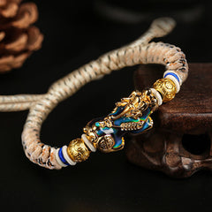Feng Shui PiXiu Bracelet – color change Pixiu gold head blue body beige cord dark background, magic
