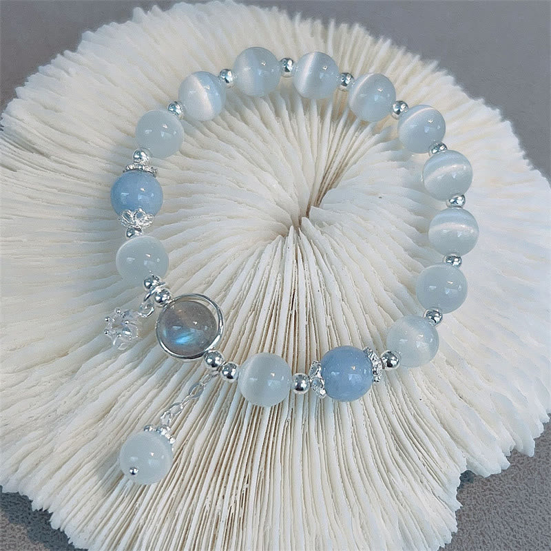 Cat's Eye Moonstone Butterfly Bracelet – Pale blue cat's eye beads with silver butterfly charm and iridescent cabochon on white pleated fan display, gray backdrop