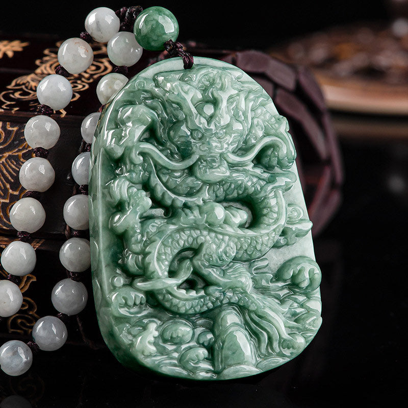 Chinese Zodiac Dragon Jade Necklace - Carved jade dragon amulet on beaded cord over dark wood box, Prosperity