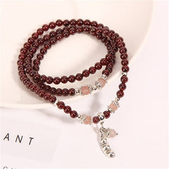 Garnet Strawberry Quartz Green Beans PiXiu Wrap Bracelet – garnet wrap bracelet on white surface, lifestyle shot