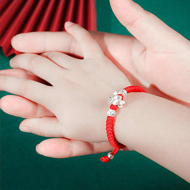 999 Sterling Silver Zodiac Red Rope Kids Bracelet - Ox charm on red cord worn by child, adult hand, blessing jewelry