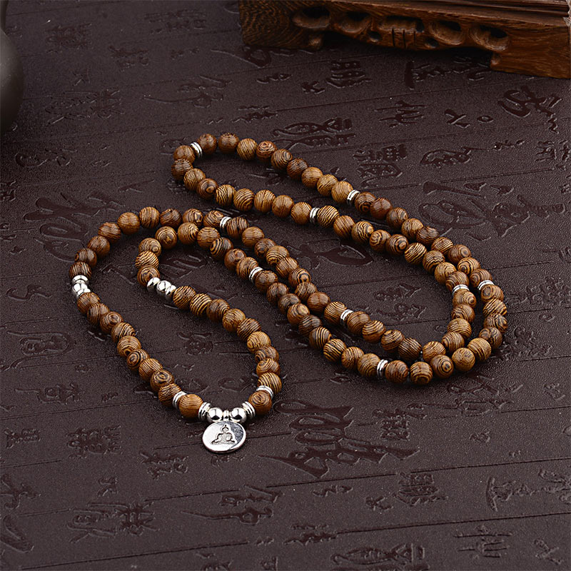 Tibetan Lightning Strike Wood Mala – full length flatlay with Buddha charm on carved surface