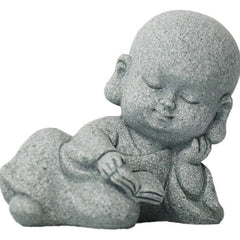 Meditation Monk Statue - Lying baby monk reading scripture, isolated white background product shot