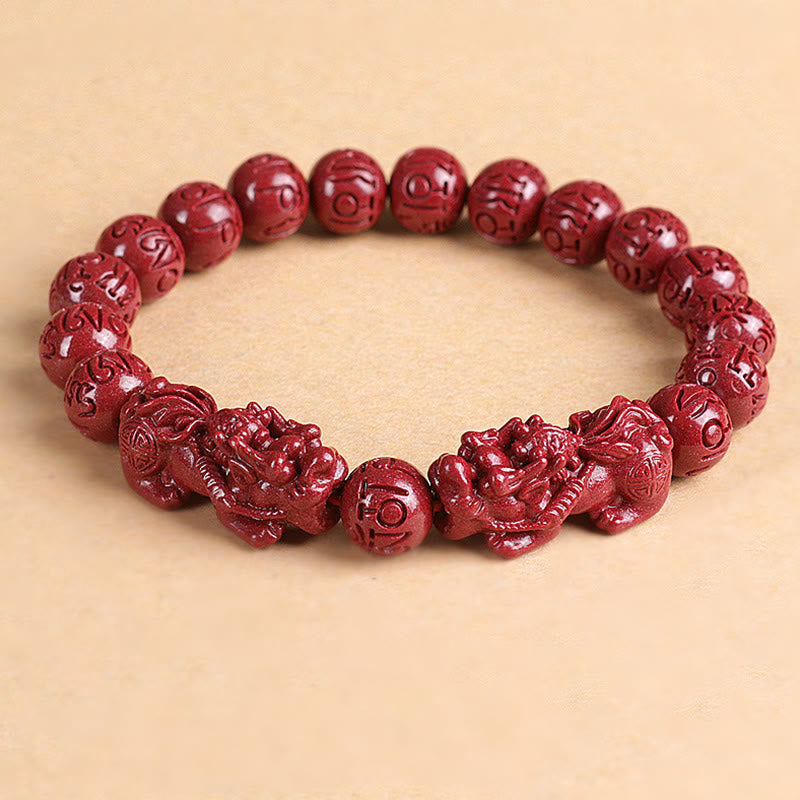 Double PiXiu Cinnabar Bracelet – Red cinnabar bead bracelet with PiXiu pair on beige background, feng shui jewelry