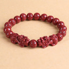Double PiXiu Cinnabar Bracelet – Red cinnabar bead bracelet with PiXiu pair on beige background, feng shui jewelry