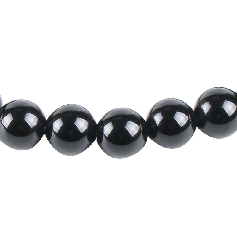 Tree of Life black onyx bracelet with glossy black obsidian beads, high reflective shine, clean product photography on white background.