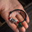 925 Sterling Silver Koi Fish Bracelet – black cord with antique silver koi charm, burgundy wraps and green tassel on palm