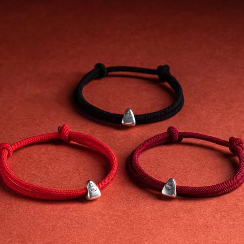925 Silver Fu Character Braided Bracelet – Three adjustable fortune bracelets in red burgundy and black cords with silver charms on warm terracotta background, selective focus