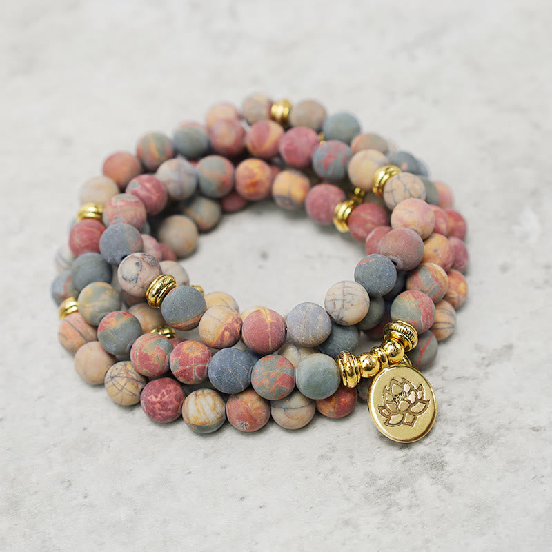 Picasso Jasper 108 Mala Bracelet - triple wrap spiral on stone surface, beaded bracelet