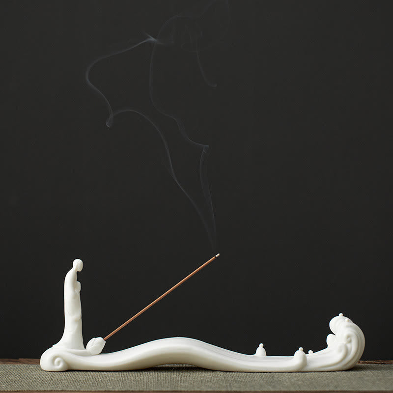 Buddha Monk Sea Wave Mountain Ceramic Incense Burner – Front view of white monk on wave with smoke trail on green mat, ceramic incense holder