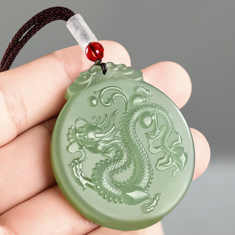 Chinese Zodiac Dragon Jade Necklace - hand-held green jade dragon pendant showing carved scales, luck jewelry