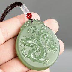 Chinese Zodiac Dragon Jade Necklace - hand-held green jade dragon pendant showing carved scales, luck jewelry