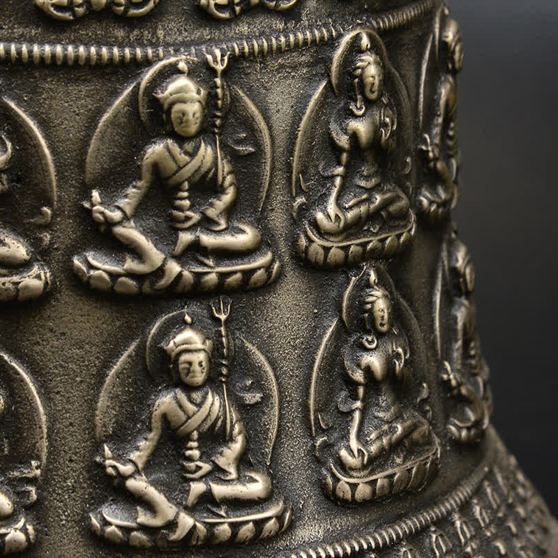 Tibetan Buddha Dragon Bell close-up seated deity relief figures on cylindrical body, trident symbols, sacred, intricate