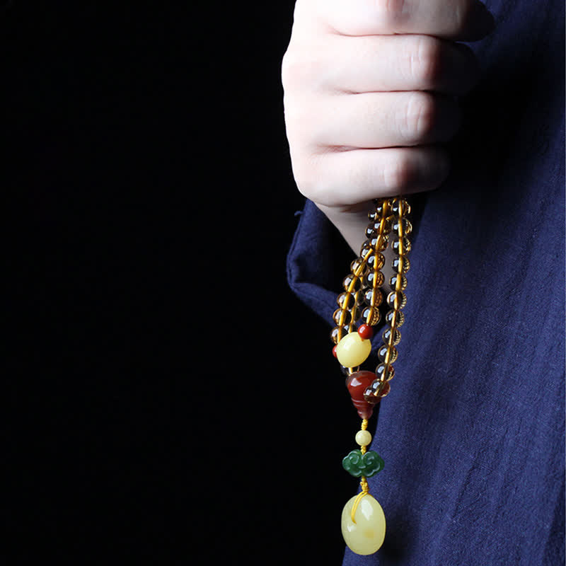 Citrine Mala Bracelet – Hand clutching citrine bead strands with red agate guru bead, dark bg