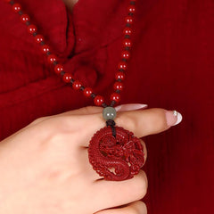 Cinnabar Hetian Jade Dragon Necklace - red dragon pendant held in hand, coiled carving detail