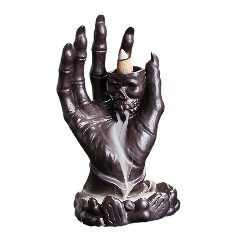 Ceramic Ghost Hand Skull Incense Burner – Dark bronze hand holding skull with backflow smoke waterfall, white background