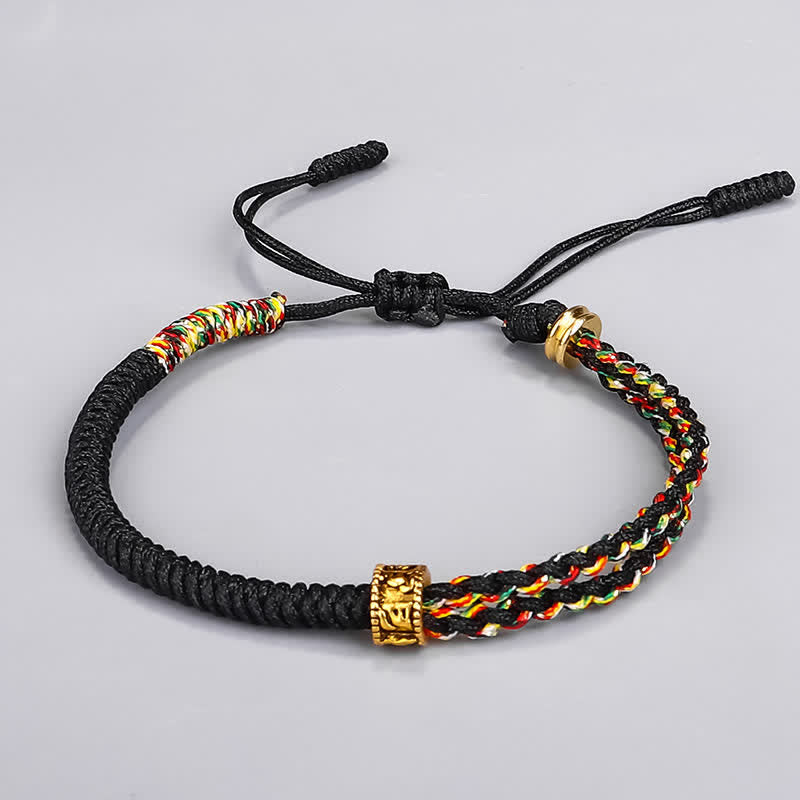 Om Mani Padme Hum Red String Bracelet – Black braided rope with colorful five-element woven section and gold engraved barrel bead on gray background