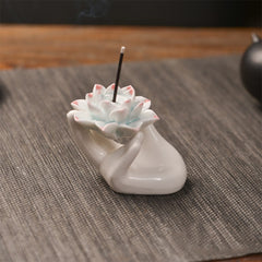 Ceramic Lotus Hand Incense Burner - hand cradling pink-tipped lotus with rising smoke, zen healing