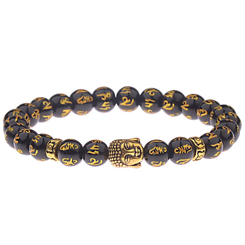Tibetan Buddha Om Mani Padme Hum Amulet Bracelet - black obsidian beads with gold Tibetan mantra inscriptions, central gold Buddha head amulet charm, gold spacer beads, stretch prayer bracelet on white background