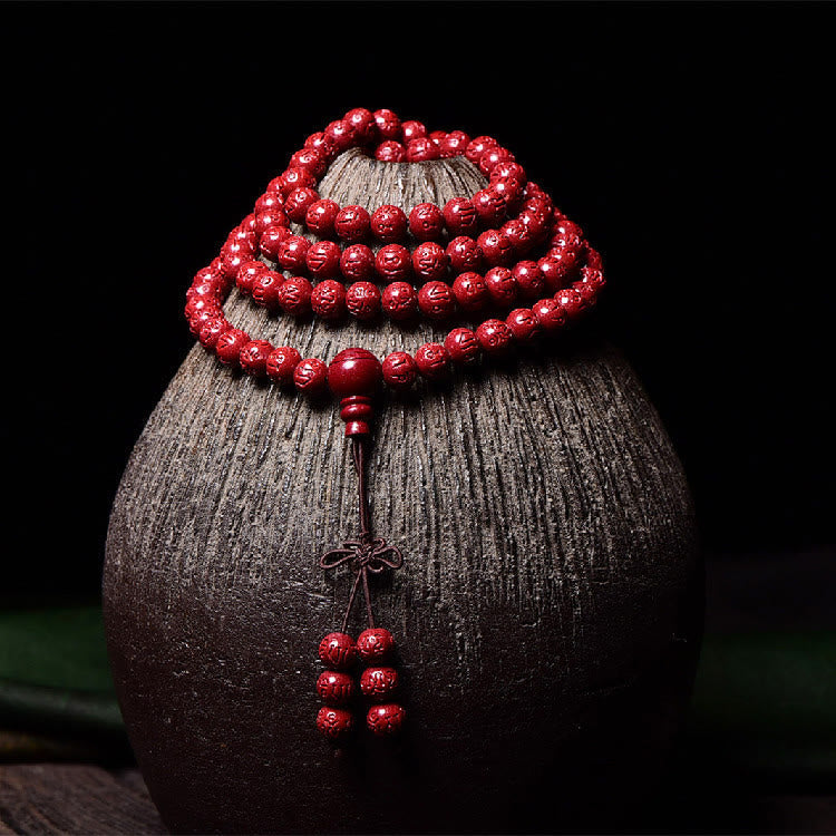 108 Mala Beads Cinnabar Bracelet – Draped on textured ceramic, red mala necklace