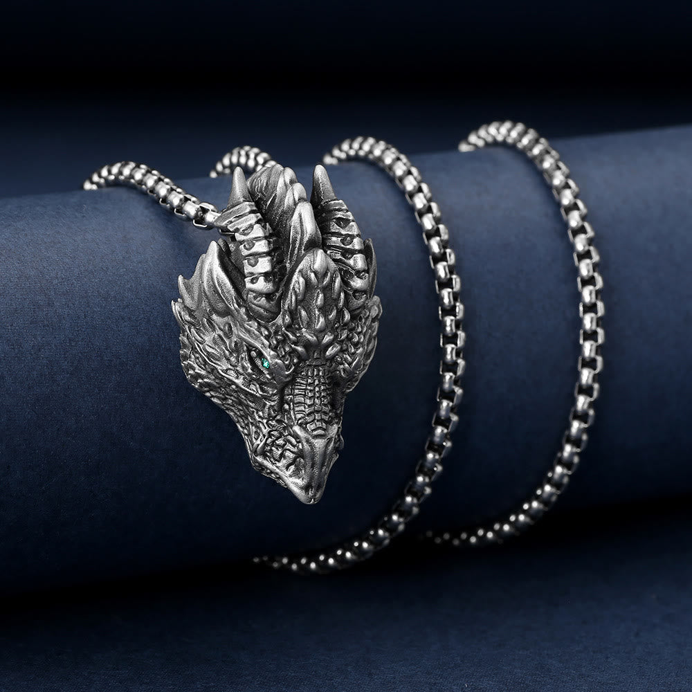 Pure Tin Dragon Head Necklace - Frontal dragon face with green stone eye on blue velvet, powerful luck
