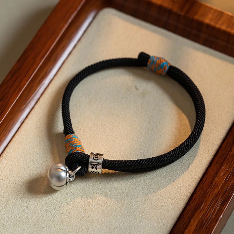 Om Mani Padme Hum Bracelet - Black cord with silver mantra bead and bell on wooden tray, Tibetan charm