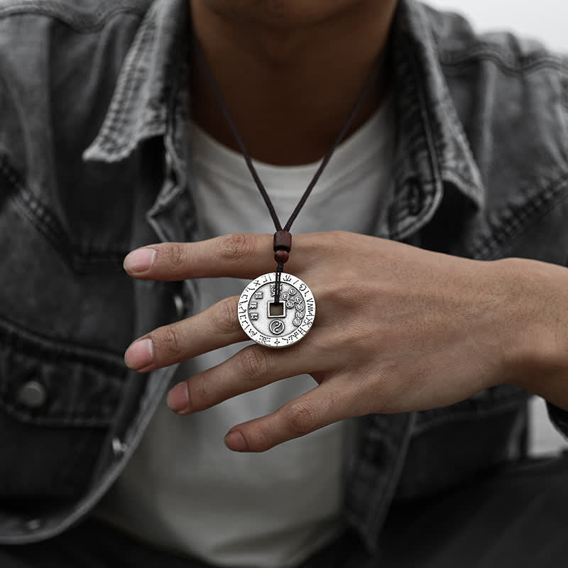 Bagua Yin Yang Obsidian Necklace - hand holding engraved coin with square hole, worn detail shot