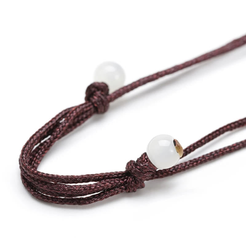 Obsidian Energy Balancing Necklace – Adjustable knot closure detail with white beads and gold tube on dark brown cord, white background close-up