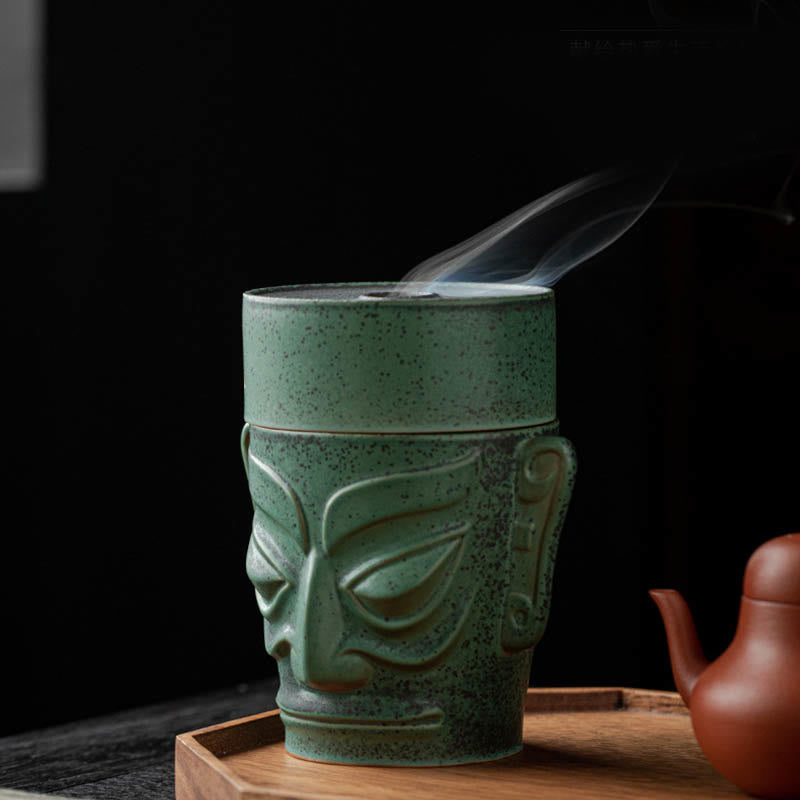 Sanxingdui Bronze Mask Incense Burner – Smoke on pure black background, terracotta teapot and meditation setting