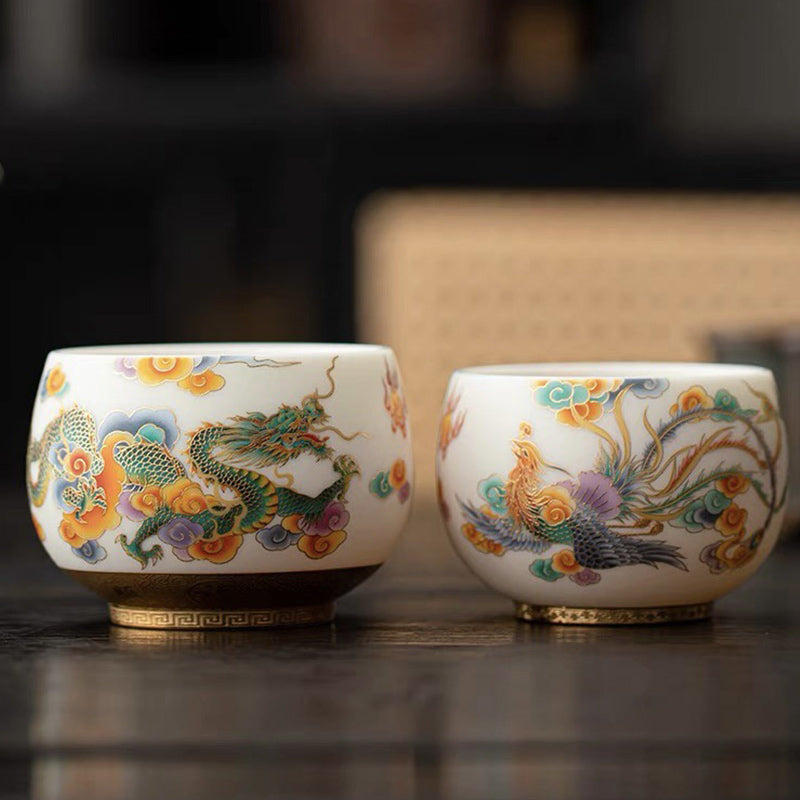 Dragon Phoenix Clouds Ceramic Teacup - Dragon and phoenix pair displayed on dark wood, traditional