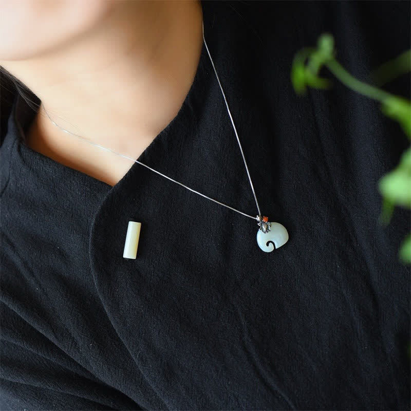 White Jade Elephant Lotus Necklace - Elephant pendant with trunk-up design on silver chain worn on black linen, lucky jewelry