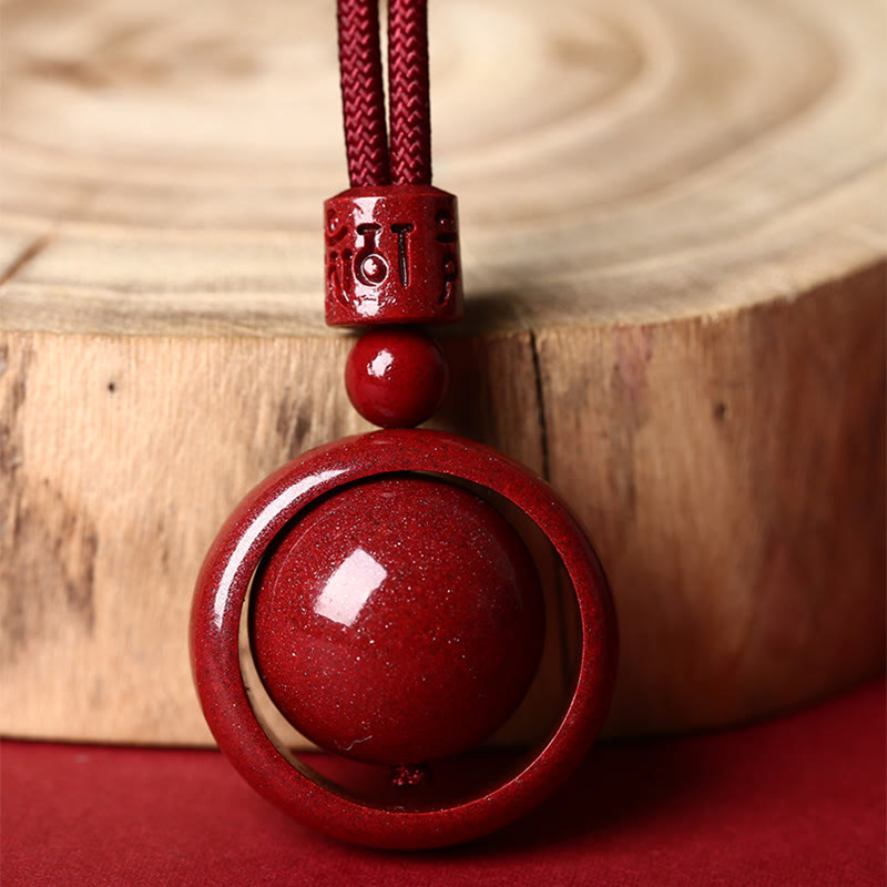 Cinnabar PiXiu Necklace – Close-up by wood slice showing Om Mani Padme Hum carving detail, luck charm
