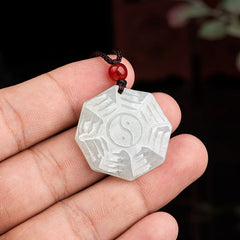 Natural Jade Bagua Yin Yang Luck Necklace - Hand holding octagonal jade bagua pendant with red bead, natural stone amulet