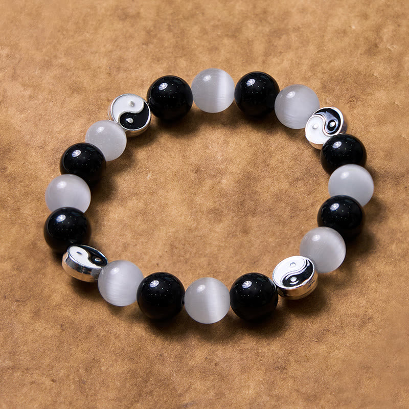 Black Obsidian Cat Eye Yin Yang Bracelet - flat lay on kraft paper showing full circular pattern, black white yin-yang bracelet