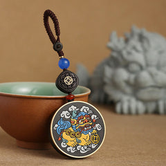 PiXiu Coin Keychain – Leaning against celadon teacup with stone lion in background