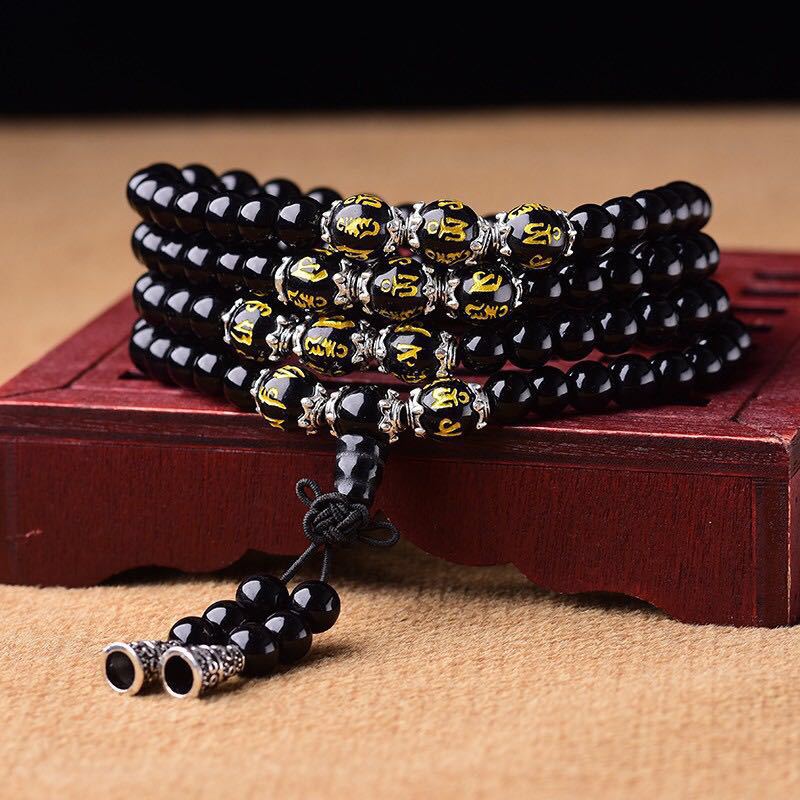 Black Obsidian Mala Bracelet - Coiled on carved wooden stand with gold mantra beads and silver spacers, obsidian prayer beads
